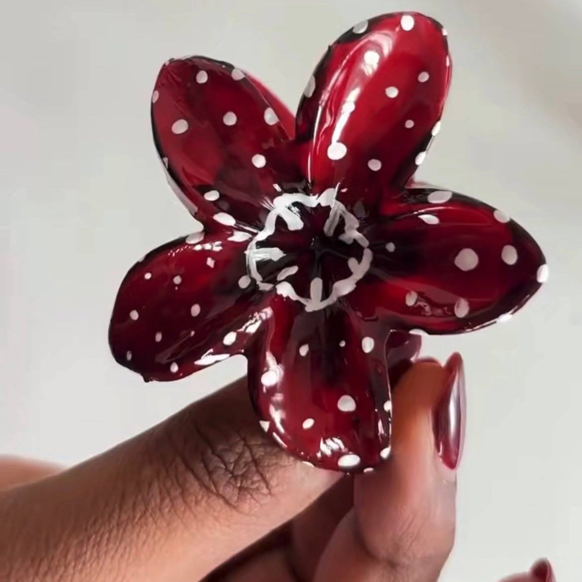 Red flower-shaped balloon with white polka dots held by a hand against a neutral background Demogorgon Hair Clip/Claws/Clutcher #Demogorgon #StrangerThingsStyle #StrangerThingsInspired #UpsideDownVibes #HorrorAesthetic #DarkAesthetic #ShopOnlineIndia #WholesaleHairAccessories #MadeInIndia #IndianBrands #AffordableFashion #HairClaws #HairClipStyle #StatementHair #TrendyHairAccessories #ClutcherLove #HairFashion #tivra #tivracreation